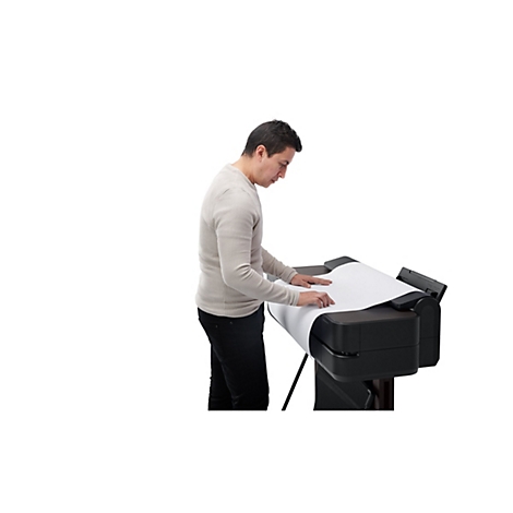 Ein Mann in beigem Pullover steht an einem grossformatigen Drucker. Er legt Papier auf die schwarze Druckoberfläche.