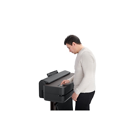 Un homme utilise une imprimante grand format. Il appuie sur un bouton.