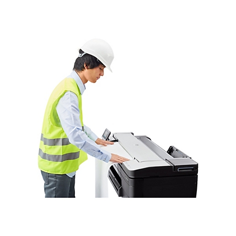 Ein Mann mit Helm und Warnweste bedient einen grossen Drucker.