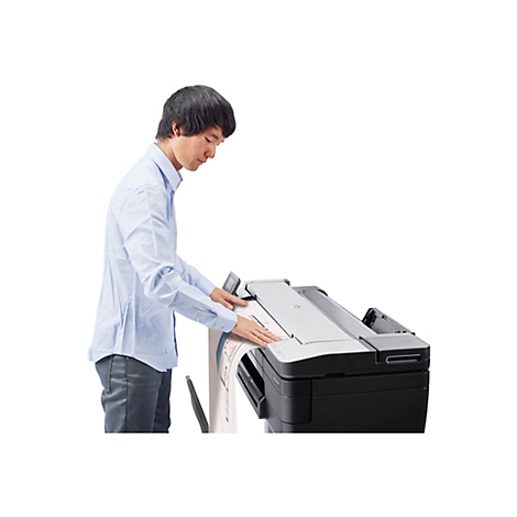 Ein Mann bedient einen GroÃŸformatdrucker. Er legt ein groÃŸes Papierdokument ein.