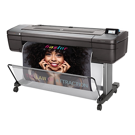 Großer HP DesignJet Drucker, zeigt ein gedrucktes Bild einer Frau. Darunter Text: The Law of Attraction.