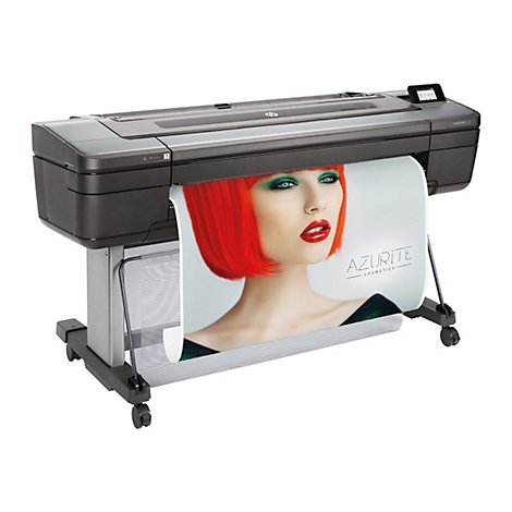 Großer, schwarzer Drucker mit einem Werbeplakat, das gerade gedruckt wird. Das Plakat zeigt ein Model mit rotem Haar und grünen Augen.