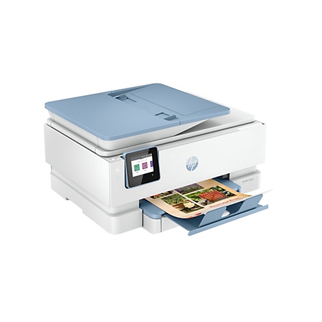 Ein weiß-blaues HP ENVY Inspire Multifunktionsgerät, das ein bedrucktes Papier mit Gartenmotiven ausgibt. Der Bildschirm zeigt Optionen für Kopie, Scan usw.
