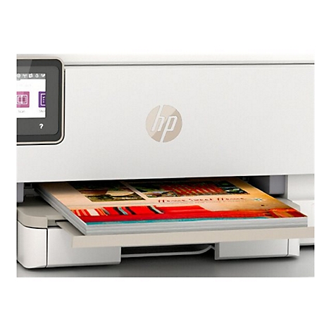 Une imprimante HP blanche imprime un document colorÃ©. Le papier est sorti du bac au milieu de l'imprimante.