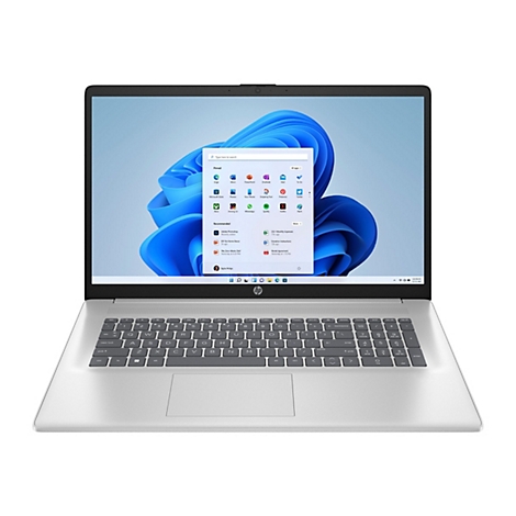 Ein silberner Laptop mit Windows-Oberfläche, der geöffnet auf einem Tisch liegt. Der Bildschirm zeigt das Windows 11-Startmenü.