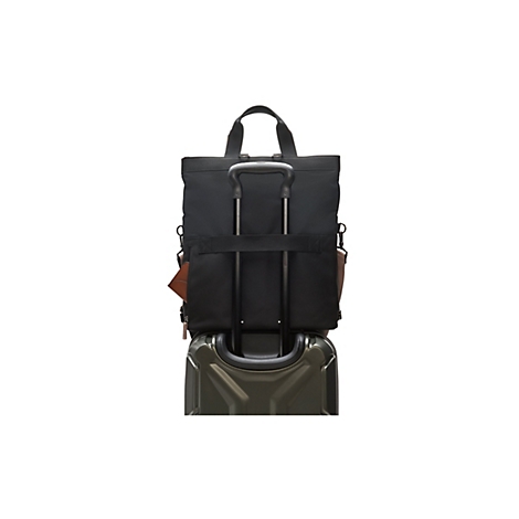 Schwarze Tragetasche auf einem olivgrünen Koffer mit ausziehbarem Griff. Ein braunes Portemonnaie steckt in der Tasche.