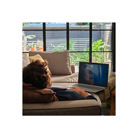 Ein Mann liegt auf einem Sofa und schaut auf einem Laptop einen Film. Das Laptop zeigt eine Frau in einem Astronautenhelm.
