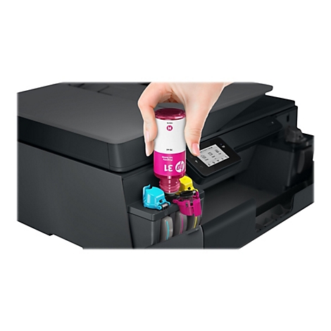 Nahaufnahme einer Hand, die eine magenta Tintenpatrone in einen Drucker einsetzt. Der Drucker ist schwarz, auf dem Display steht "July 15 2019 11:00 AM".