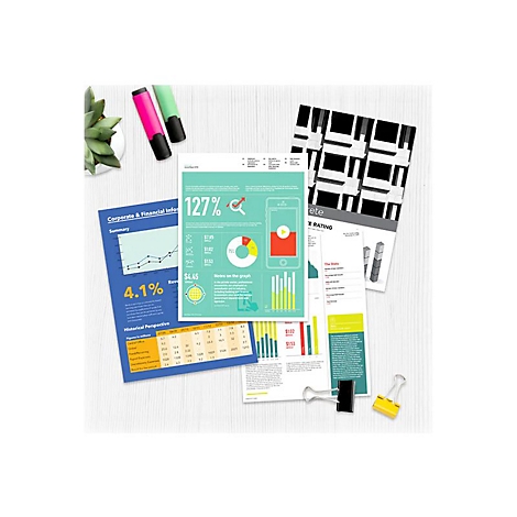 Draufsicht auf Tabellen, Grafiken und Diagramme. Einige Stifte und eine kleine Pflanze liegen daneben. Zwei Büroklammern halten Papier zusammen.