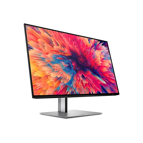 Moderner PC-Monitor mit dünnem Rahmen auf silbernem Standfuß, zeigt ein buntes, abstraktes Explosion-Hintergrundbild.