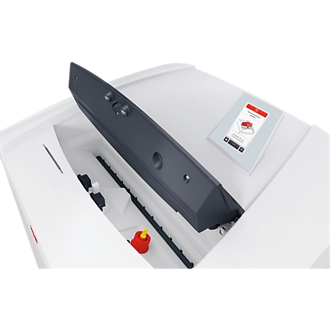 Detailopname van een witte machine met een grijze deksel. Een rode knop is zichtbaar.