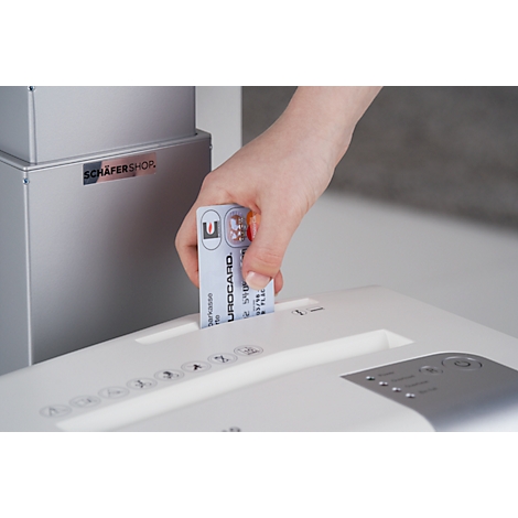 Hand inserts Eurocard into paper shredder.