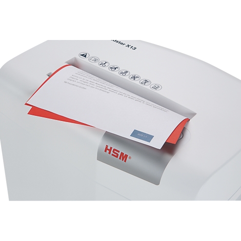 A white paper shredder is shredding a document that is partially visible. Red edge and blue text on the paper.