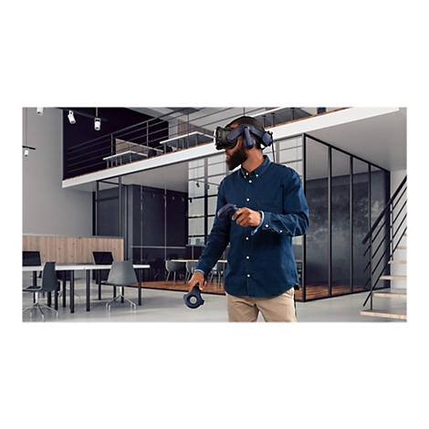 Ein Mann mit VR-Brille in einem Büro. Er hält Controller. Im Hintergrund sind weitere Büromöbel zu sehen.