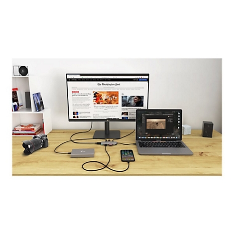 Bureau avec ordinateur portable, moniteur et accessoires. Un site web est visible sur le moniteur, une vidÃ©o sur l'ordinateur portable.
