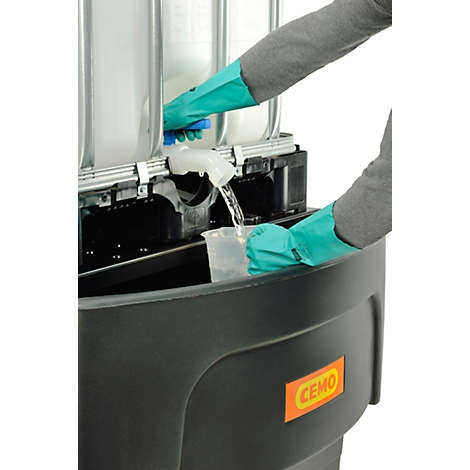 Person with gloves filling liquid into a measuring cup. A black collection container is below.