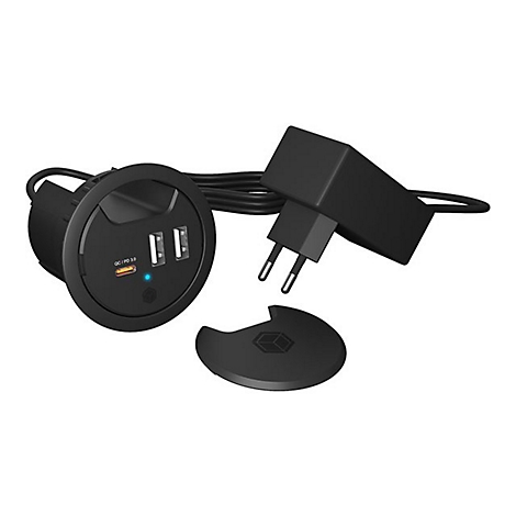 Chargeur USB noir, forme ronde, deux ports USB, adaptateur secteur et couvercle à côté.