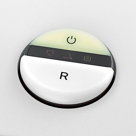 Round, white button with black symbols and the inscription R.