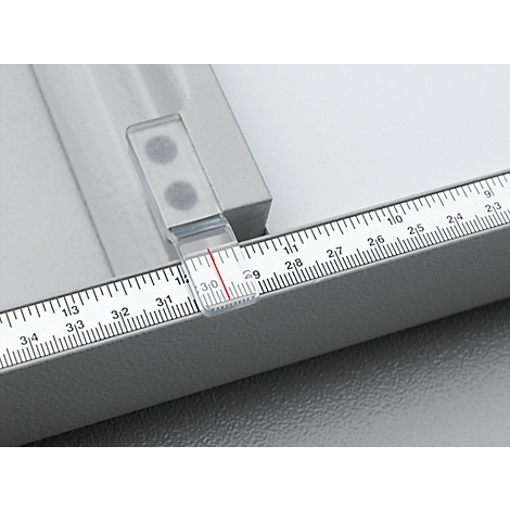 Close-up of a gray ruler with a transparent marker placed at 3.0. Numbers and lines for measurement are printed on the ruler.