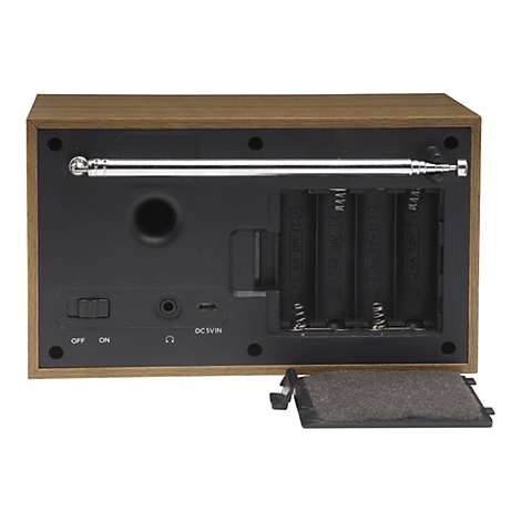 Rückseite eines Radios in Holzoptik mit geöffnetem Batteriefach, Antenne und Anschlüssen auf weißem Grund.