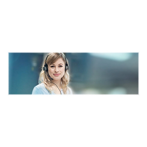 Eine blonde Frau mit Headset lächelt in die Kamera. Sie trägt ein hellblaues Oberteil vor unscharfem Hintergrund.