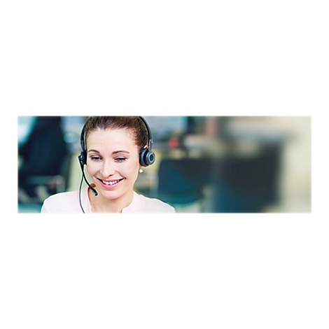 Eine lÃ¤chelnde Frau mit Headset. Sie schaut auf ihren Bildschirm und sieht glÃ¼cklich aus.
