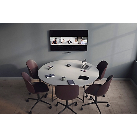 Ein runder Konferenztisch mit Stühlen in einem modern eingerichteten Büro mit Videokonferenzbildschirm an der Wand.