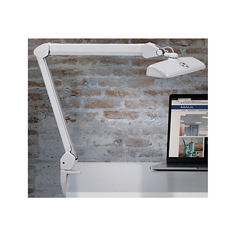 Weiße Schreibtisch-Klemmlampe mit Gelenkarm vor einer Backsteinwand neben einem Laptop.