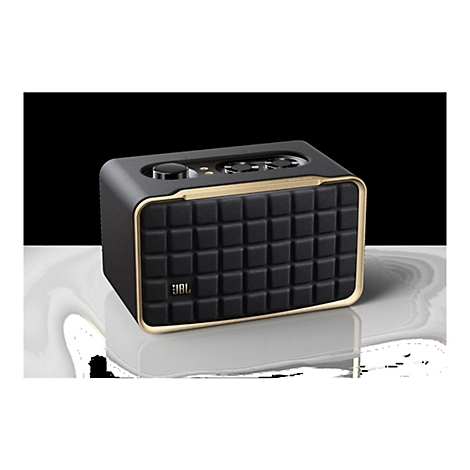 Schwarzer JBL Lautsprecher im Retro-Design mit goldfarbenem Rahmen auf reflektierender Oberfläche.