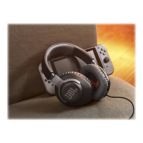 Schwarzer JBL-Kopfhörer liegt auf einem grauen Stuhl. Dahinter ist eine Nintendo Switch.