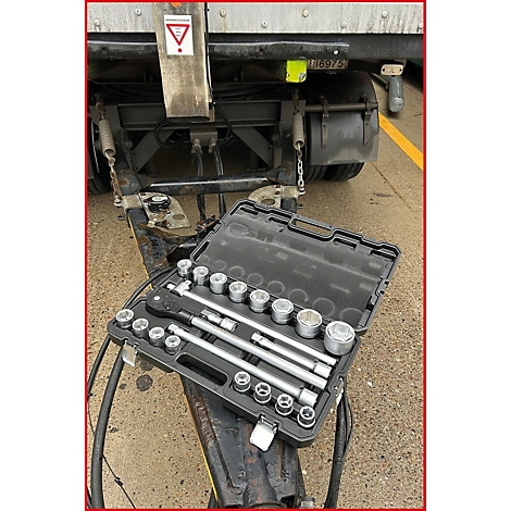 Une boîte à outils avec un jeu de douilles posée sur la flèche d'une remorque.