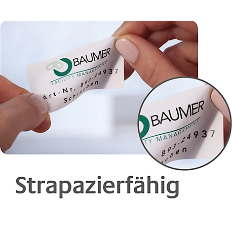 Mains tenant une étiquette de la société Baumer. L'étiquette présente un logo, des informations et l'inscription "Strapazierfähig".