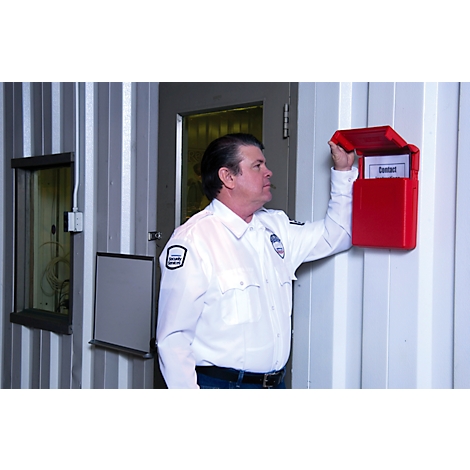 Ein Mann in Uniform öffnet einen roten Briefkasten an einer Wand. Auf dem Zettel im Briefkasten steht "Kontakt".