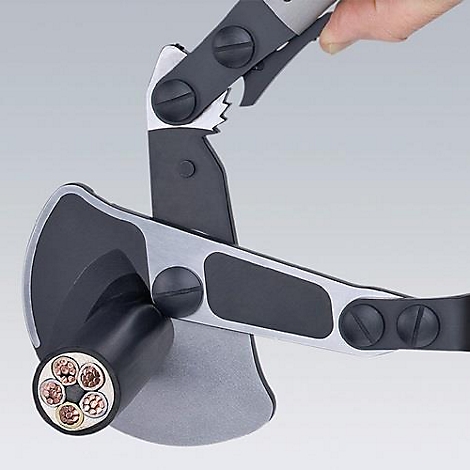 Kabelkniptang snijdt kabel. De koperdraden zijn zichtbaar. Een arm houdt het gereedschap vast.