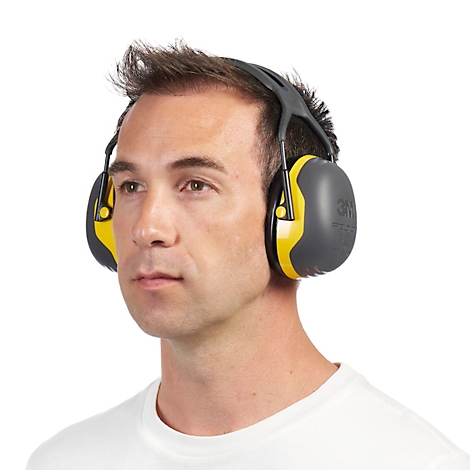 Schwarzer Gehörschutz von 3M Peltor auf einer Verpackung. Aufgedruckte Schriftzüge, wie "EARMUFFS COMFORT". Gelbe Akzente.