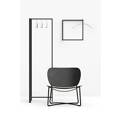 Zwarte design stoel tegen een witte achtergrond. Tevens een kledingrek, een frame met een boog.