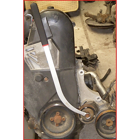 Ein gebogener Werkzeugschlüssel wird an einem Motor eingesetzt.