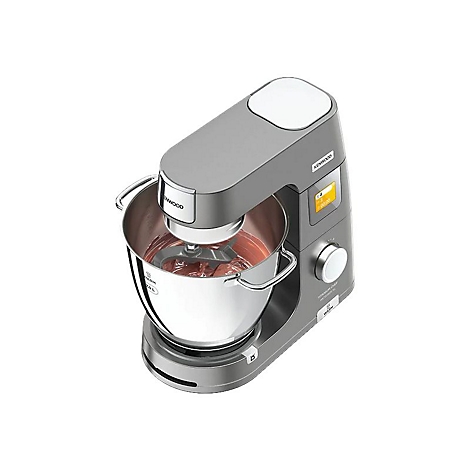 Graue Kenwood Küchenmaschine mit Edelstahlschüssel, in der eine rötliche Masse von einem Knethaken bearbeitet wird.