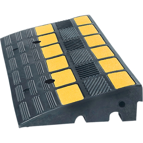 Black rubber ramp with yellow squares and holes for cables. The surface is textured.