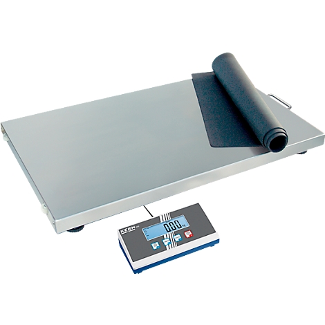 Balance avec un tapis noir enroulé. L'écran affiche '000'.