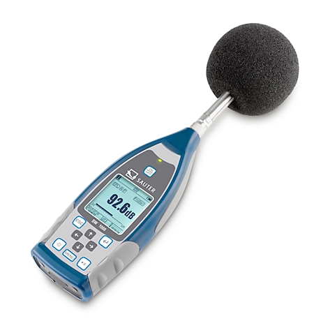 Ein Schallpegelmessgerät mit Anzeige 92,6 dB. Schwarze Mikrofonkugel auf Metallarm, blauer und grauer Griff.