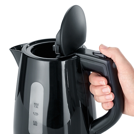Close-up of a black kettle, opened and held by a hand. A water level indicator is visible.