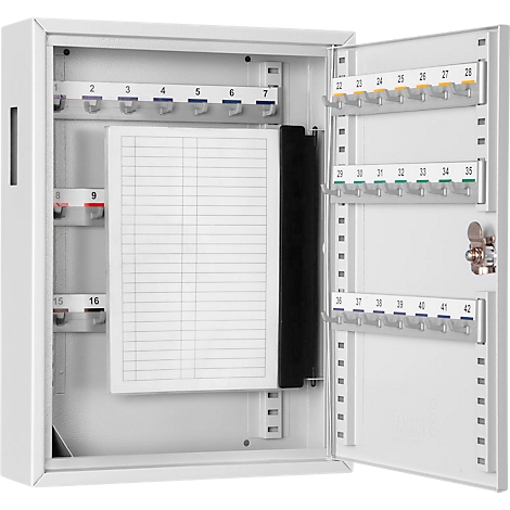 White key cabinet with open door. Hooks for keys, numbered from 2 to 42. There is a notepad on the inside.