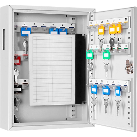 Open white key cabinet with keys and labeled tags. A paper list in the middle.
