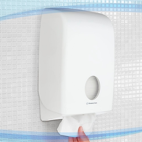 Witte papieren handdoekdispenser aan witte muur, een hand trekt papier.