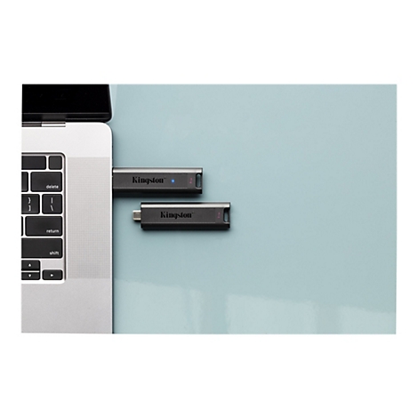 USB-Stick von Kingston neben einem Laptop. Auf blauem Hintergrund.