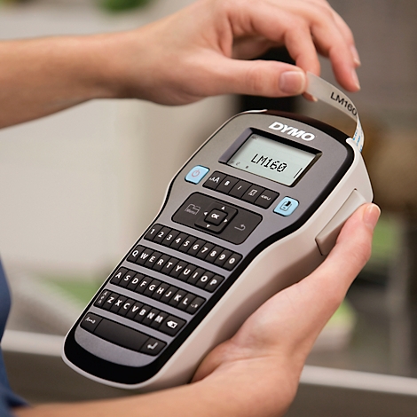 Une personne tient une étiqueteuse portable Dymo LM160 et tire une étiquette fraîchement imprimée.