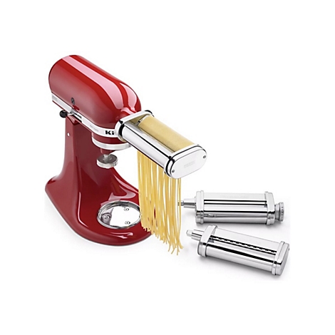 Rote KitchenAid Küchenmaschine mit aufgesetztem Nudelvorsatz, aus dem frische Spaghetti herabfallen.