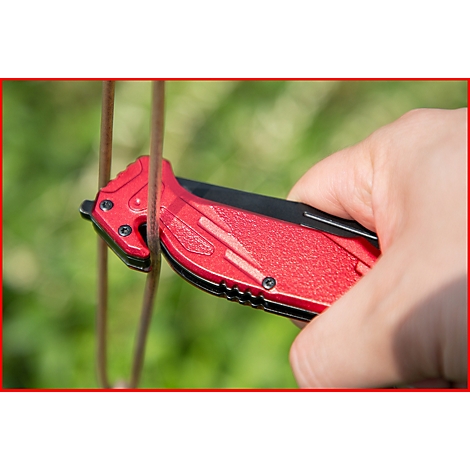 Eine Hand hält ein rotes Klappmesser, das einen braunen Stab durchtrennt.