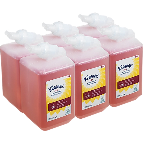Six pink liquid soap dispensers, labeled Kleenex Joy, stand side by side.